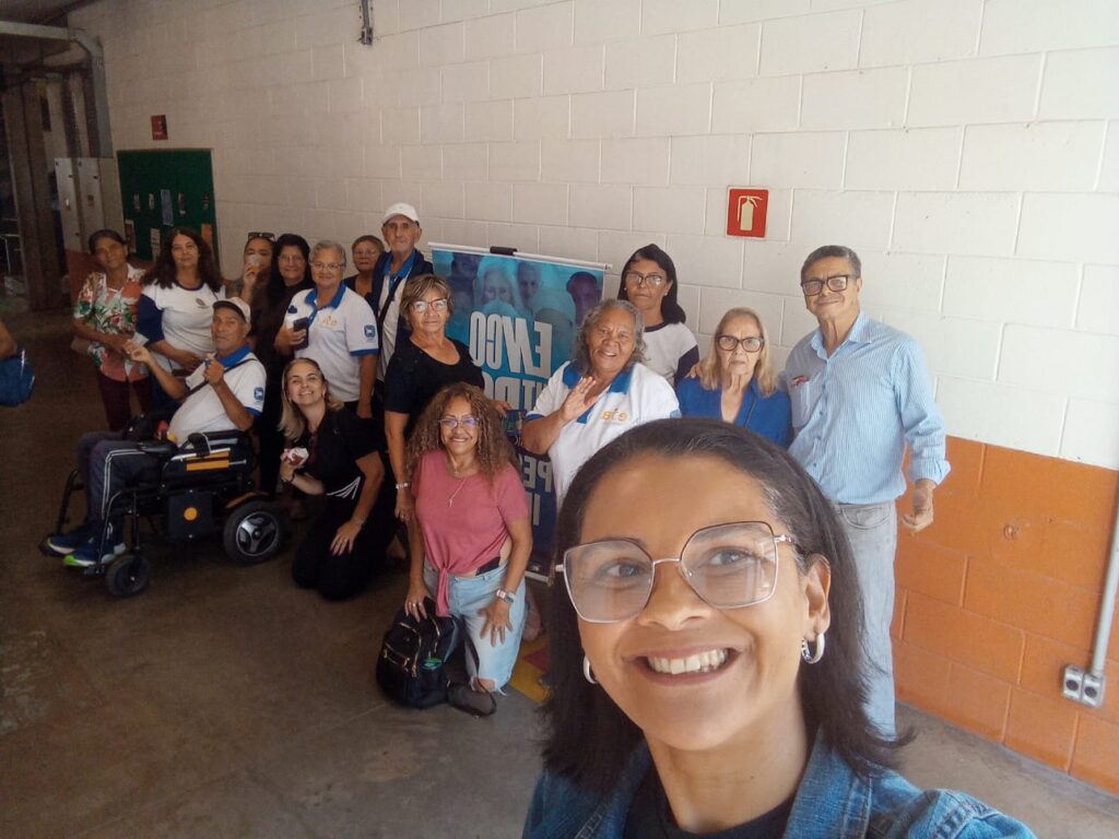 Grupo de pessoas idosas e educadora reunidos no Encontro Regional da Pessoa Idosa
